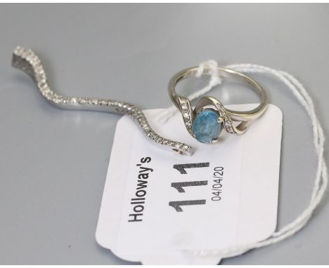 A diamond set scroll shaped pendant, and a diamond and topaz cross over ring