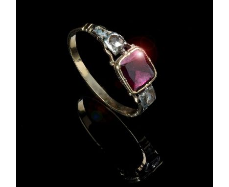 A gentleman's 19ct century three stone garnet and diamond ring, the central rectangular garnet in reeded cup mount, the shoul