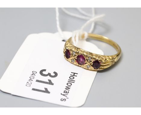 A ruby and diamond seven stone half hoop ring, the three oval cut rubies in carved mount with four stone diamond detail to pl