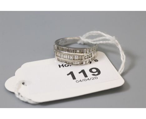 A three tow diamond ring, set with baguette diamonds, the tapering shoulders with two stone brilliant cut diamonds, the plain