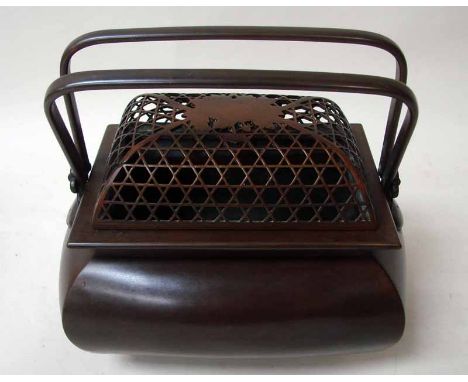 An oriental bronze box of compressed rectangular form with pierced domed removable cover and twin swing handle, 19cm long 