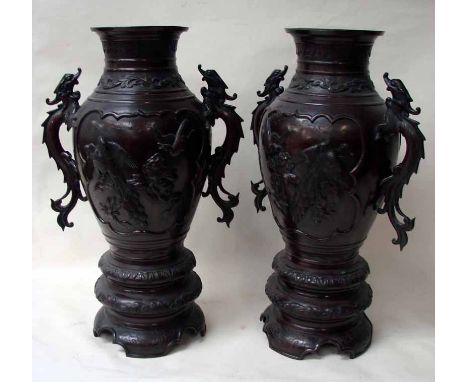 A large pair of Japanese Meiji bronze vases of two handled baluster form the bodies decorated with opposing panels of exotic 