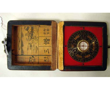 A Chinese brass and black enamel Pocket Compass in a square hinged box externally red lacquered and gilt decorated with an ex