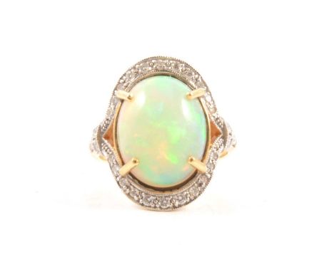 An opal and diamond cluster ring, the oval cabochon cut opal, 15 x 12mm, four claw set in an 18 carat yellow and white gold c