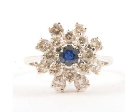 A sapphire and diamond cluster ring, a central sapphire surrounded by an inner circle of eight brilliant cut diamonds and out