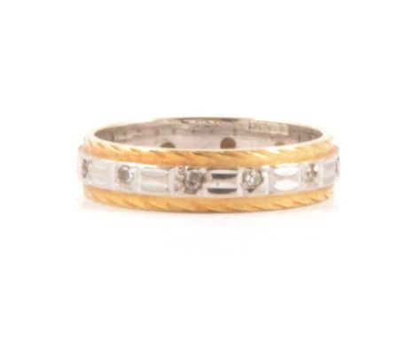 An 18 carat yellow and white gold eternity ring, the white gold centre set with small diamonds and having a bright cut yellow