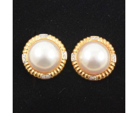 A pair of pearl and diamond earrings, the 13.5mm blister pearls set in 18 carat yellow gold mounts, fluted bezel set with fou