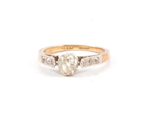 A diamond solitaire ring, the old brilliant cut stone claw set in a yellow and white metal mount ring size K, shank marked 18