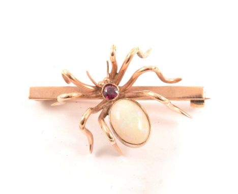 A spider brooch, an oval cabochon cut opal, 9.5 x 6mm set to the abdomen, red stone to body, mounted on a 35mm yellow metal b