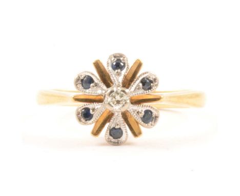 A sapphire and diamond cluster ring, a brilliant cut diamond surrounded by six sapphires in an 18 carat yellow and white gold