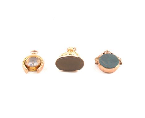 Three 9 carat gold fobs, a 9 carat yellow gold seal with a plain oval onyx to base, Birmingham 1910, height 30mm; a swivel fo