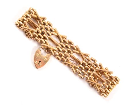 A rose metal 21mm wide cross design gate link bracelet, marked 9ct, fitted with a padlock fastener and safety chain, 33.8g. 
