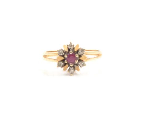A ruby and diamond cluster ring, a single ruby surrounded by six brilliant cut diamonds in a yellow and white metal floral de