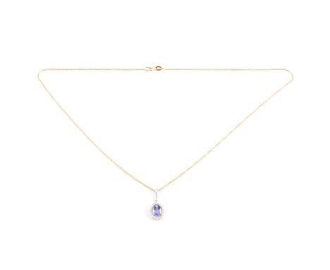 A tanzanite and diamond pendant and chain, the oval mixed cut tanzanite 7x5mm, four claw set and surrounded by a halo of twen