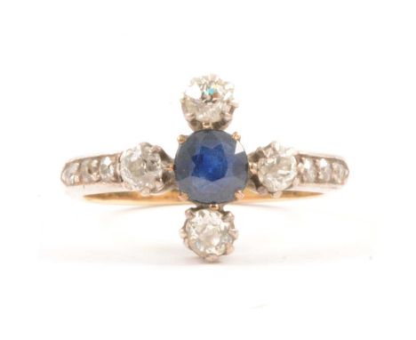 A sapphire and diamond ring, a central circular sapphire claw set with four old cut diamonds set in a cross design ring size 