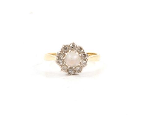 A moonstone and diamond cluster ring, the 6mm round conical shaped moonstone surrounded by ten early Swiss cut diamonds in a 