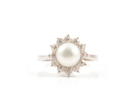 A cultured pearl and diamond ring, an 8.7mm button pearl peg set and surrounded by twelve old cut diamonds in an all-white me