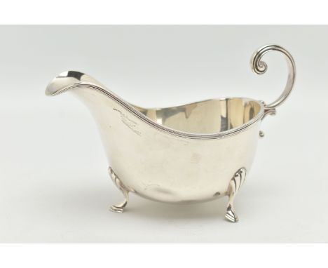 A SILVER GRAVY BOAT, polished form, raised on three hoof feet with shell pattern, and a scroll handle, hallmarked 'Walker &am