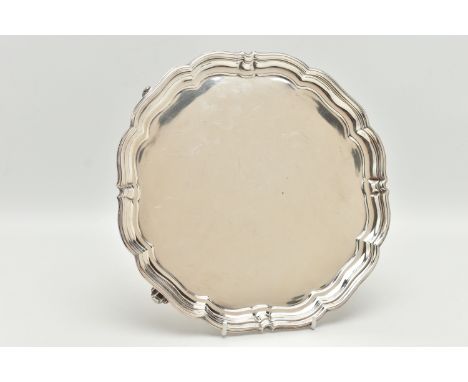 A GEORGE V SILVER PRESENTATION SALVER, of a circular form with wavy rim, raised on four scroll feet, reverse engraved 'Presen