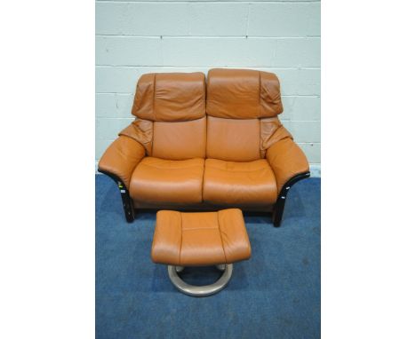 AN EKORNES STRESSLESS TWO SEATER RECLINING SOFA, 154cm x depth 78cm x height 106cm, along with a footstool (condition report: