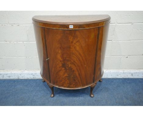 A 20TH CENTURY FLAME MAHOGANY DEMI-LUNE CABINET, with a single door, that's enclosing three shelves, raised on cabriole legs,
