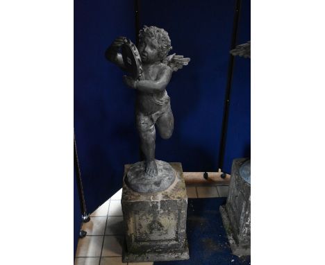 A SECOND HALF 20TH CENTURY WEATHERED BRONZE FIGURE OF CHERUB POSED HOLDING A TAMBOURINE, on a naturalistic circular base, whi