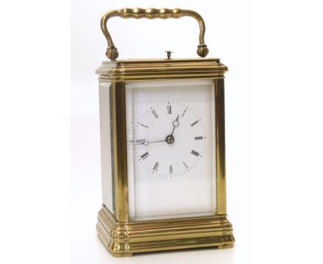 A brass framed carriage clock with bevelled glass panels to top and sides. With white enamel dial and Roman numerals. Eight-d