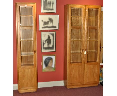 Two Ercol Windsor light elm wall units, the larger with a pair of glazed doors, 84 x 36in. (213.5 x 91.5cms); the other with 