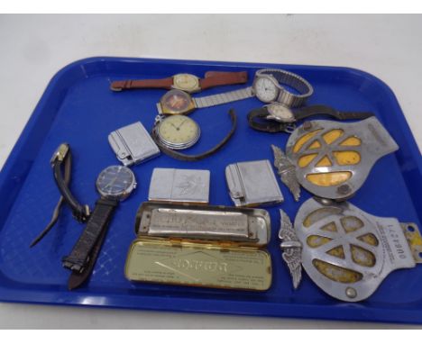 A tray containing vintage AA badges, assorted wristwatches, lighters, Hohner Super Vamper harmonica in a Dunlop cycle repair 