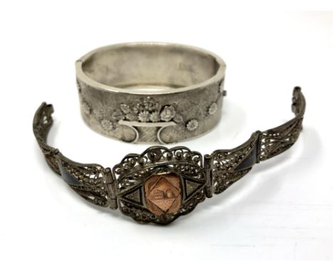 A silver cuff bangle with floral decoration, 32.4g, Birmingham 1876, together with a Continental silver filigree panel bracel