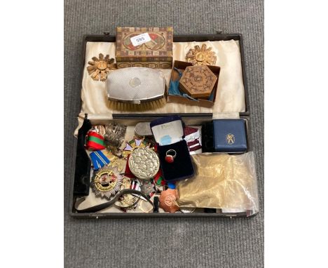 A box containing Russian medals and badges, a silver cup holder, a novelty "Hohner" accordion brooch, a silver-backed brush, 