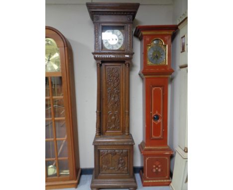 A carved oak black forest style longcase clock with brass and silvered dial 