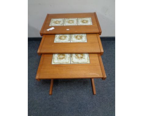 A nest of three mid 20th century teak tile topped tables 