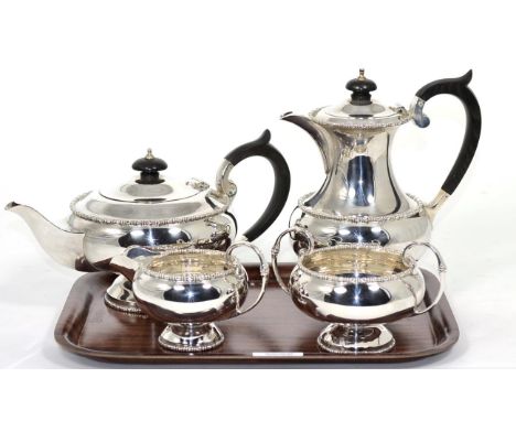 A four piece silver tea service, Walker & Hall, Sheffield 1964-66, circular pedestal form, the hot water jug 20cm high, 49.6o