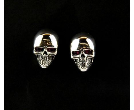 A pair of 925 silver skull earrings set with rubies, H. 1.3cm.