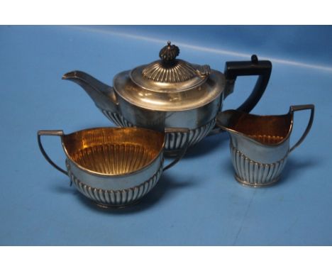 A HALLMARKED THREE PIECE SILVER TEA SET COMPRISING TEAPOT, CREAM JUG AND SUGAR