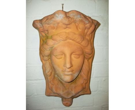 A TERRACOTTA WALL HANGING PLANTER DEPICTING A FACE