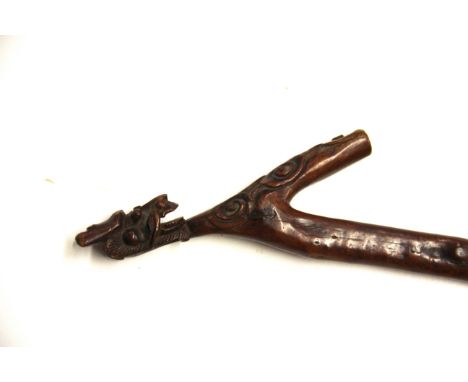 A carved hardwood Welsh dragon walking stick, L. 94cm.