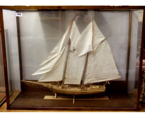 A large glass cased handmade wooden model of a two masted scooner, case 87 x 67 x 31cm. Prov. Bertie Bardell estate.