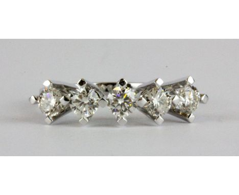 A white metal (tested 18ct gold) ring set with five brilliant cut diamonds, approx. 1.2ct, (M).