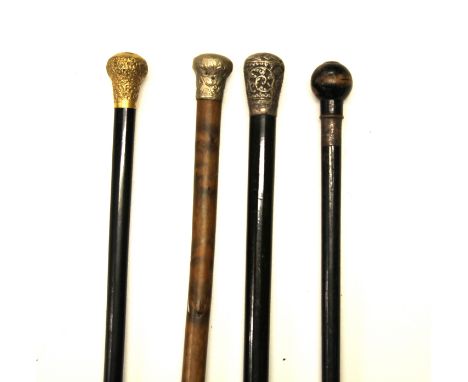 An 18ct gold plated handle walking stick and three others.