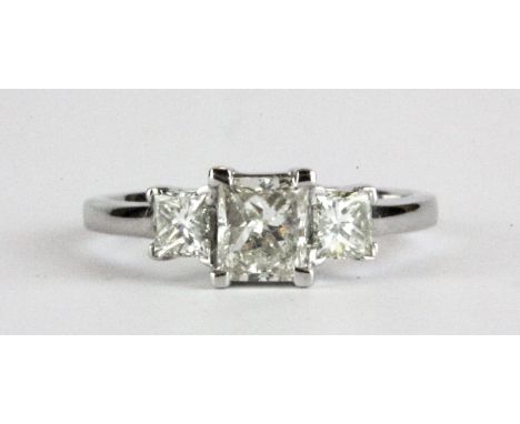 An 18ct white gold (stamped 18k) ring set with three princess cut diamonds, centre approx. 1ct, shoulders 0.60ct overall, (N.