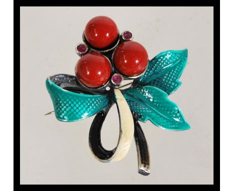 An enamel set brooch in the form of a holly leaf having a hinge pin fastening.