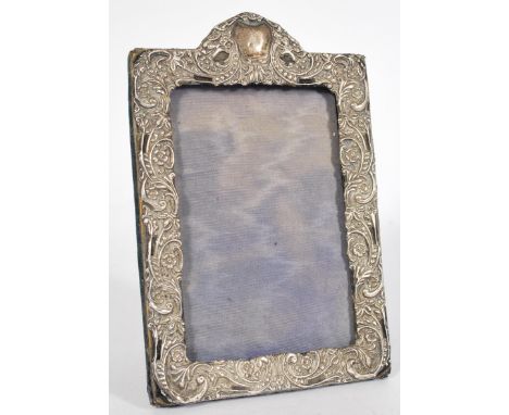 A silver hallmarked easel back picture frame with scrolled flower head design.&nbsp;Measures: 20cm high x 13cm wide.