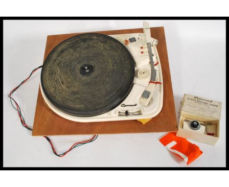 A Garrard 4HF vintage four speed record player, with auto stop, with its original rubber platter, on a painted white metal pl