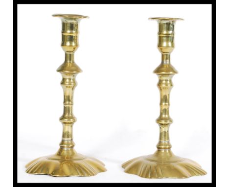 A pair of Georgian early 18th century brass candle stick holders with splat floral bases and graduating Knopf's with splayed 