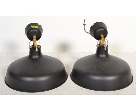 A pair of contemporary retro style ceiling pendant light fixtures, black finish to the outer with a reflective white glaze to