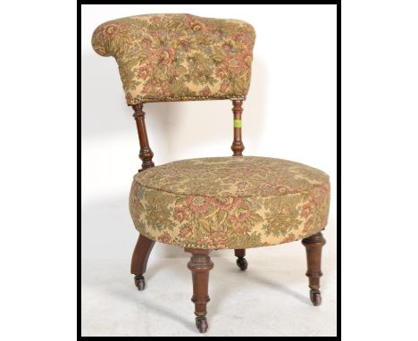 A 19th Century Victorian mahogany framed nursing chair, over stuffed circular seat pad with button back back, raised on turne