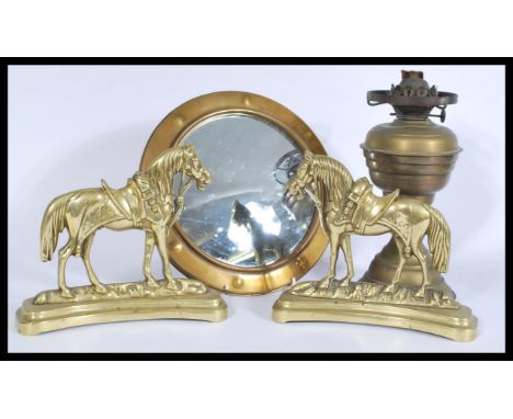 A collection of brass items to include brass horses, circular brass fish eye mirror and an oil lamp.&nbsp;Measures: 26cm diam