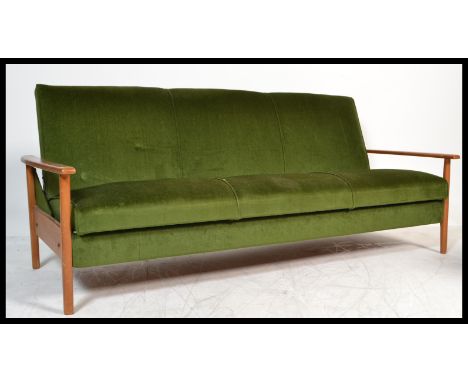 A retro 1960's Danish inspired teak wood day bed sofa. The turned legs supporting a fold down bed completed by shaped arms. M